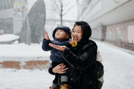 mother and child playing in the snow